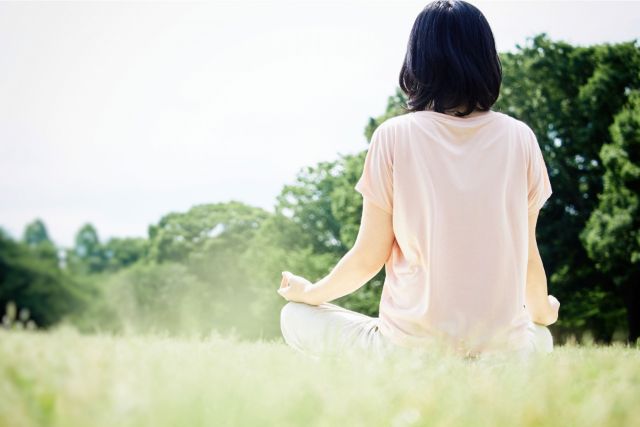 草原で瞑想をする女性